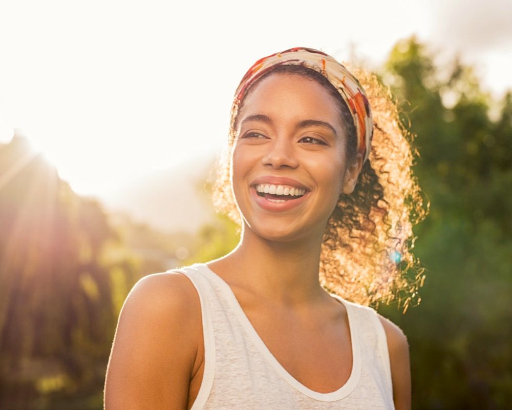 Woman smiling with sunrise behind her